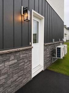 a white door on the side of a house at Modern Riverview Suite Near Downtown Moncton in Riverview