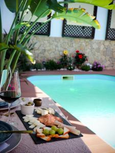 a plate of food on a table next to a swimming pool at Opus One Guest House in Faro