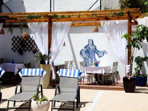 a table and chairs in front of a mural of a man at Opus One Guest House in Faro