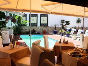 a restaurant with a pool and tables and chairs at Opus One Guest House in Faro