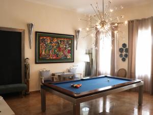 a living room with a pool table and a chandelier at Opus One Guest House in Faro
