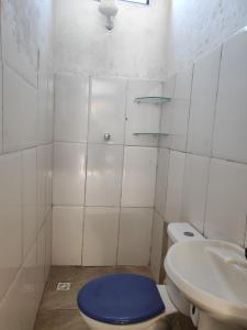 a bathroom with a blue toilet and a sink at Cantinho da Lobeira in Alto Paraíso de Goiás +49 photos