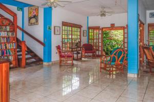 a living room with chairs and a table and bookshelves at Hotel Gracia in San Juan del Sur