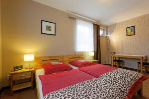 a bedroom with a large bed with red pillows at Pension Maria am Schlosspark in Gotha