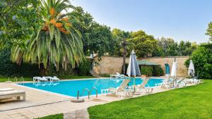 a swimming pool with chairs and umbrellas next to a yard at Bio Agriturismo Il Cavone in Sovana