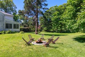 three chairs and a fire pit in a yard at Featured in Cape Cod Life Magazine in Barnstable