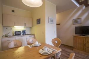 a kitchen and dining room with a wooden table and chairs at Bergschlössl - Massionettwohnung 22 in Oberaudorf