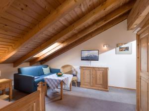 a living room with a blue couch and a table at Mit einem Traumblick App 37 in Oberaudorf