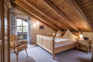 a bedroom with a bed and a chair and a window at Mit einem Traumblick App 37 in Oberaudorf