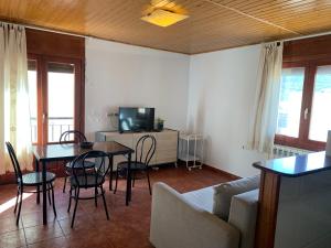 a living room with a table and chairs and a television at Apartamento Uno in Guadalaviar