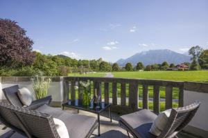 a patio with chairs and a table with a view at Villa Stigloh in Oberaudorf +5 photos