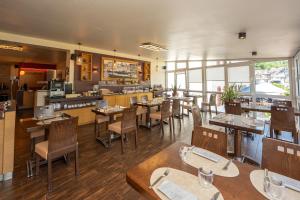 ein Restaurant mit Tischen und Stühlen und einer Küche in der Unterkunft Hotel La Baia in Cochem