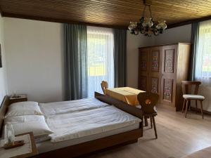 ein Schlafzimmer mit Bett, Stuhl und Fenstern in der Unterkunft Rupertihof in Fuschl am See