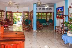 a lobby with chairs and tables in a building at Hotel Gracia in San Juan del Sur