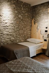 a bedroom with a bed and a stone wall at Albulena Hotel & Camping in Shkodër