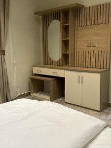 a bedroom with a bed and a vanity with a mirror at فندق أوريون orion hotel in Al-ʿUla