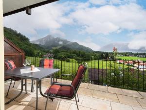 a table and chairs on a balcony with a view of a mountain at Erdgeschosswohnung 8 im Bergschlössl in Oberaudorf