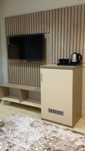 a living room with a tv and a white cabinet at فندق أوريون orion hotel in Al-ʿUla