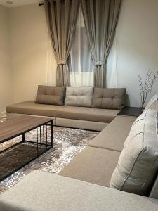 a living room with a couch in front of a window at فندق أوريون orion hotel in Al-ʿUla +2 photos