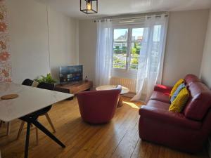 a living room with a couch and a table at Atria SILS in Caen