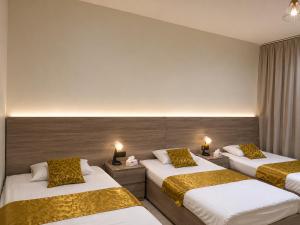 a hotel room with two beds and two lamps at فيلا وشاليه الجبل الاحمر in Al-ʿUla