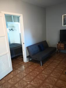 a living room with a couch and a mirror at Nice Guest House in Artesia