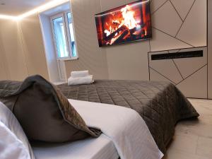 a bedroom with a bed with a tv on the wall at Премиум квартира в современном стиле in Līsakovsk