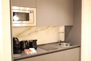 a kitchen with a sink and a microwave at Mariano Suites in Stigliano +16 photos