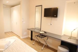 a room with a desk with a tv on the wall at Mariano Suites in Stigliano