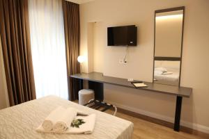 a hotel room with a desk and a mirror at Mariano Suites in Stigliano