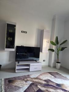 a living room with a flat screen tv on a stand at Royal Green Haven 3BR Apartment near Airport Obour in Obour