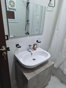 a bathroom with a white sink and a mirror at Royal Green Haven 3BR Apartment near Airport Obour in Obour +30 photos