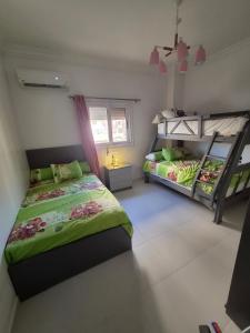 a bedroom with two bunk beds and a window at Royal Green Haven 3BR Apartment near Airport Obour in Obour
