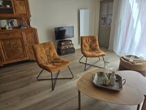 a living room with two chairs and a table at Chez mamie in La Rochelle