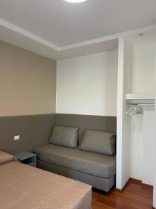 a room with two beds and a couch at B&B Casa Claudio in San Giovanni Rotondo