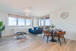 a living room with a table and a blue couch at Thameside Suite | Free Parking | 2 BR | Heathrow in Staines