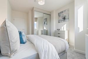 a white bedroom with a large white bed and a mirror at Thameside Suite | Free Parking | 2 BR | Heathrow in Staines