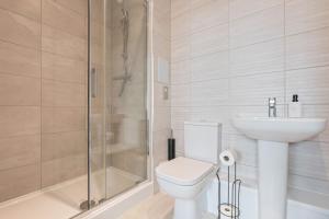 a bathroom with a shower and a toilet and a sink at Thameside Suite | Free Parking | 2 BR | Heathrow in Staines