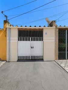 a building with a white garage door at Pousada CTI in Taubaté