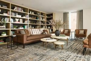 a living room with a couch and tables and shelves at Archer Hotel Old Town Alexandria in Alexandria