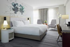 a hotel room with a large white bed and a desk at Archer Hotel Old Town Alexandria in Alexandria +101 photos