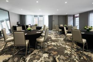 a conference room with tables and chairs and windows at Archer Hotel Old Town Alexandria in Alexandria