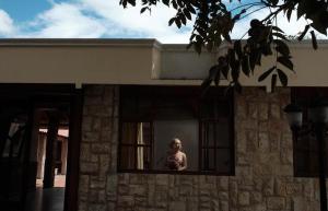 a woman is looking out of a window at Hosteria Quinta Aidita in Guano