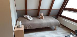 a teddy bear sitting on a bed in a room at Gite Pinot Blanc n°3 à Kaysersberg in Kaysersberg