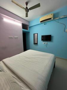 a bedroom with a bed and a ceiling fan at The grand chateau in Singapperumālkovil