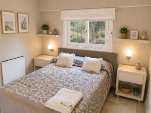 a bedroom with a bed with two pillows and a window at Tierra Mora Casas de alquiler in Villa Gesell