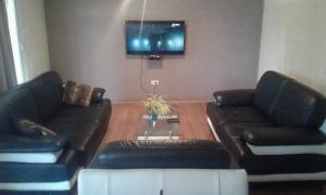 a living room with two leather couches and a tv at Buljarica Bay Apartments in Petrovac na Moru