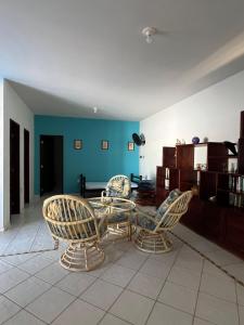 a living room with a table and chairs and blue walls at Casa com piscina em Canoa Quebrada in Canoa Quebrada
