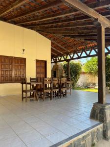 a wooden table and chairs under a wooden pergola at Casa com piscina em Canoa Quebrada in Canoa Quebrada