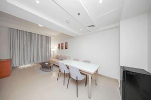 a living room with a table and chairs and a couch at Acacia Hotel Ras Al Khaimah by AMR in Ras al Khaimah